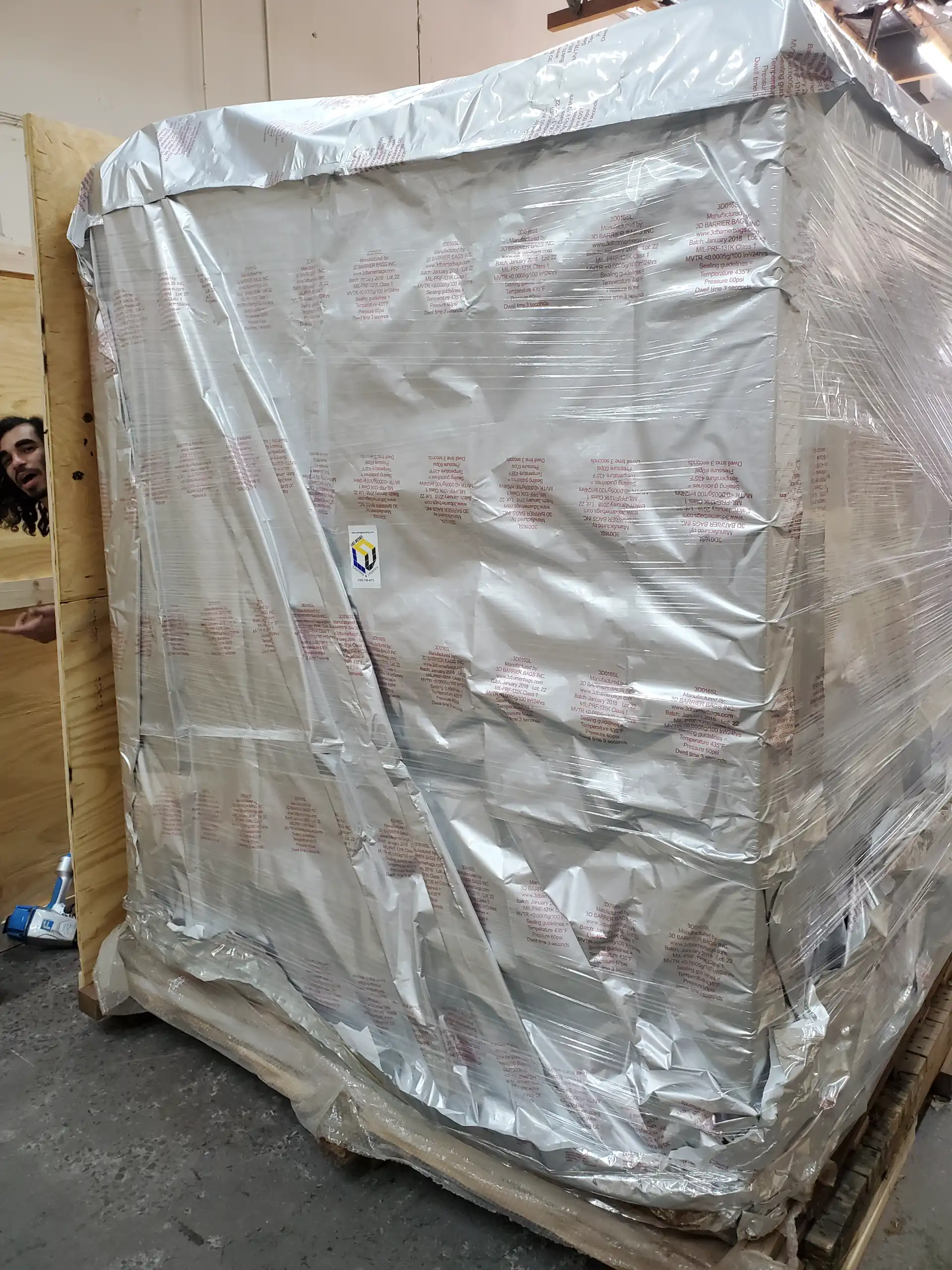 Staff finishing a vapor barrier wrapped crate
